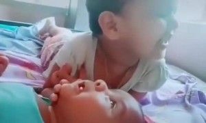 ഒരു വാവ വേറെയൊരു വാവയെ ഉറക്കുന്ന കാഴ്ച